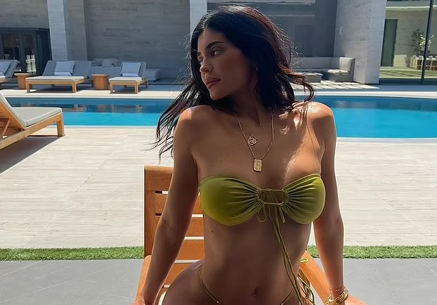 Kylie Jenner stuns in a skimpy green bikini as she soaks up the sun during a relaxing day by the pool